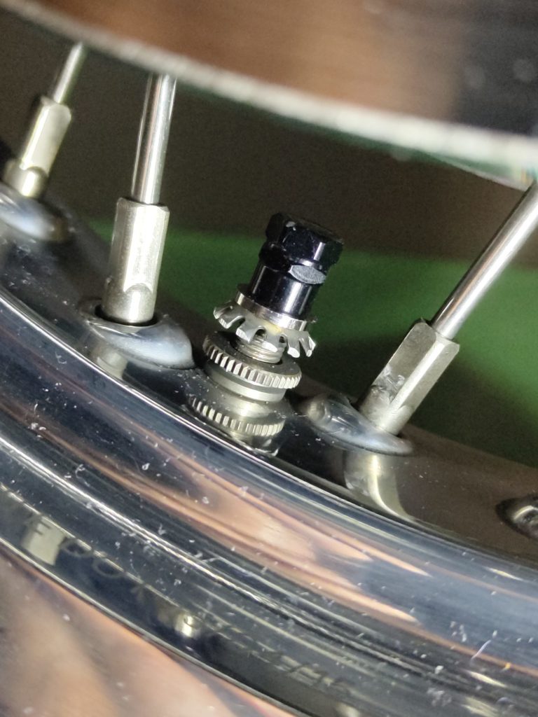 タイヤバルブに取り付けた放電ナットのクローズアップ。放電効果の有無を検証する様子