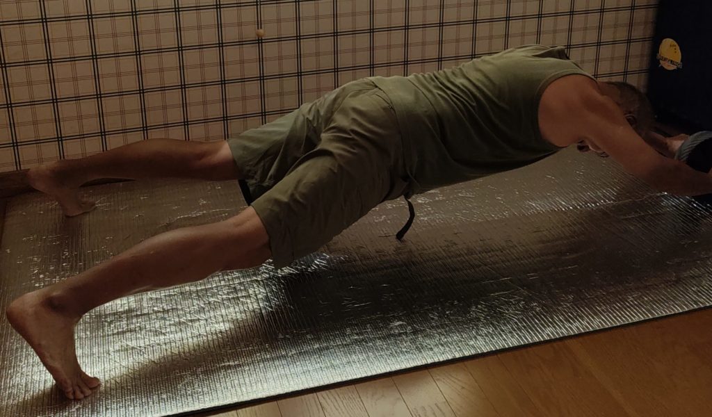 腹筋ローラを使ってトレーニングしている１シーン。体を伸ばして体形をいじしている様子