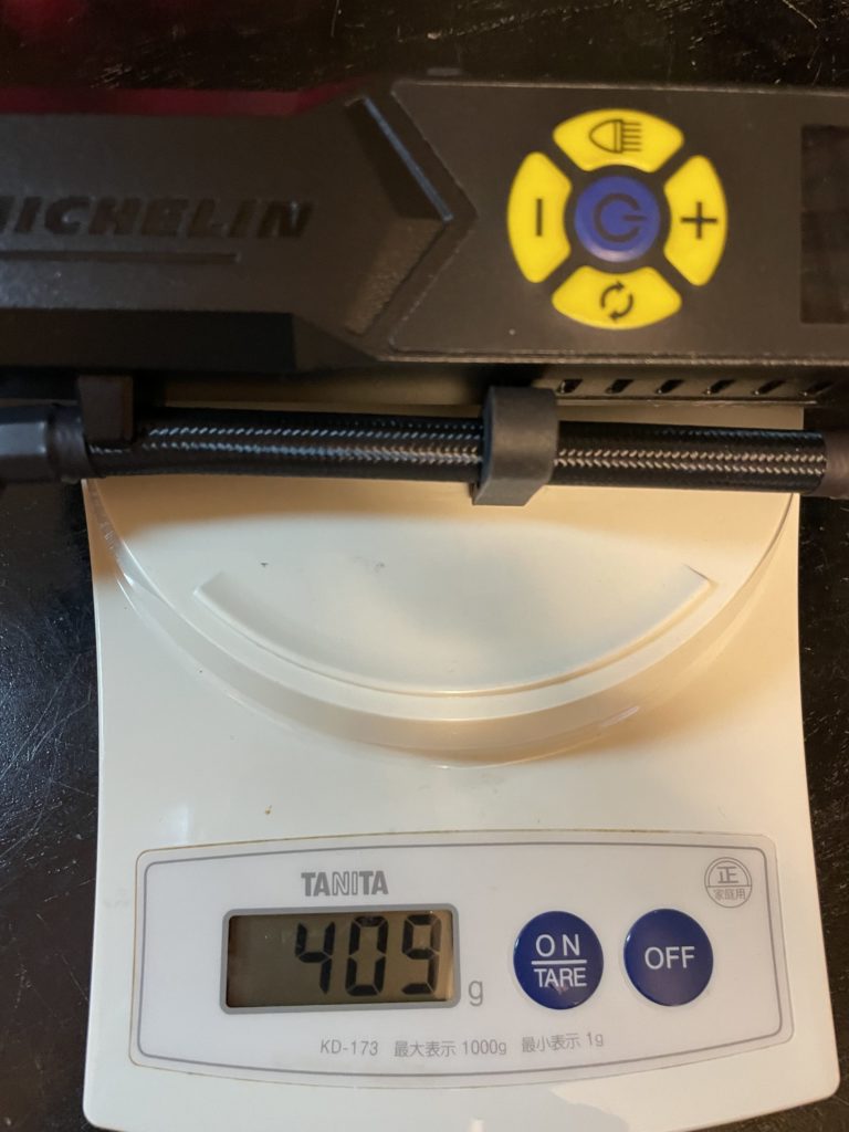 ミシュラン電動空気入れの重量を計測中の画像。指示値は４０９ｇを指している