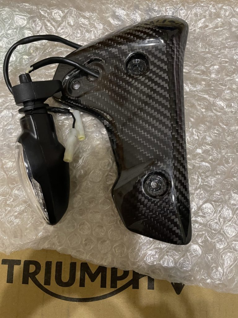 Triumph Speed Triple 1200RR の右ラジエターカバーとウインカー。カバーを取り外した状態で、ウインカー配線や固定部の構造が分かる写真。